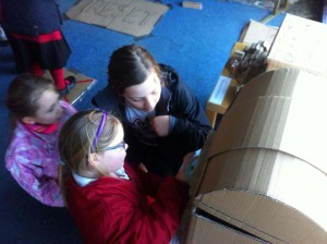 children playing with cardboard furniture